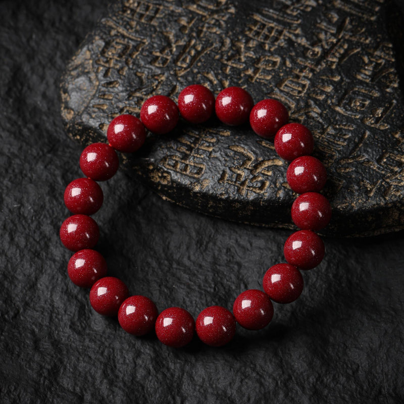 Armband med cinnoberamulet och malapärlor